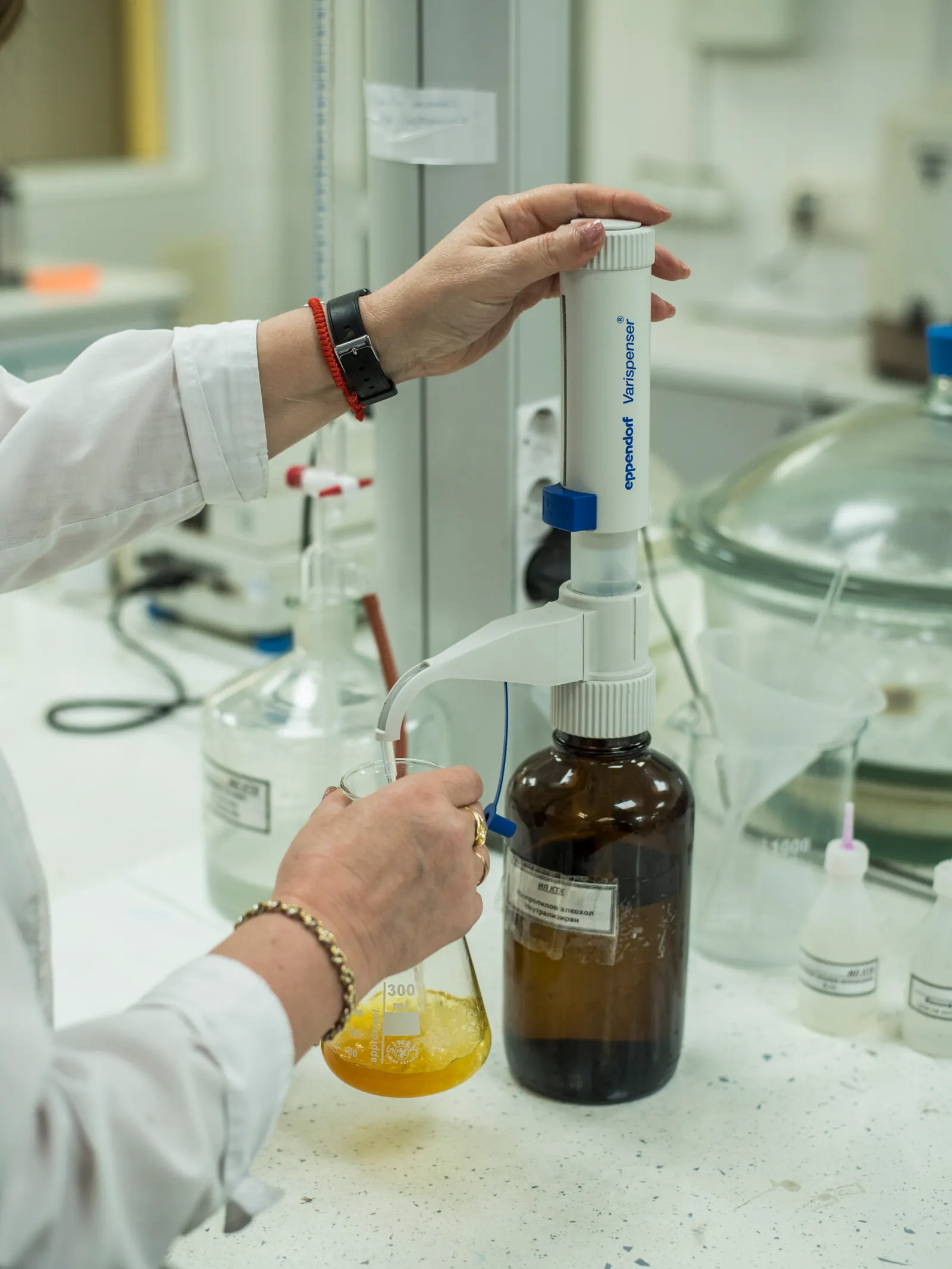 A technician in the Astra Bioplant laboratory measuring a biodiesel sample into a flask.
