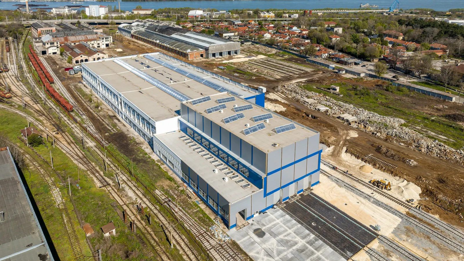 The works and the industrial park from the air — halls, tracks and wagons in the yard.