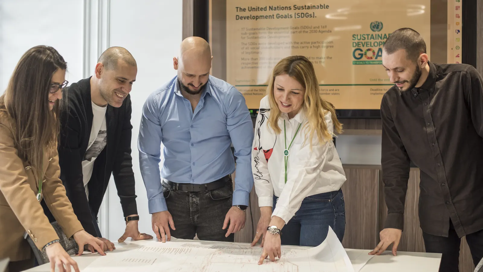 Colleagues discussing drawings in the plant's meeting room.